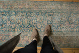 Decorative distressed Persian Meshed runner with ocean green palmettes and visible wear.