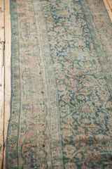 Distressed texture revealing knot heads and faded ocean green floral motifs.