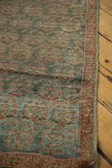 Distressed Malayer runner showing worn pile, faded ocean green and blush red germinating botehs.