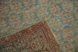 Worn pile and fringed edge of a distressed Malayer runner with faded ocean green and raspberry patterns.