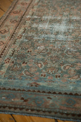 Close-up of distressed Malayer runner showing worn deep ocean green and blush Herati motif.
