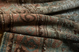 Distressed vintage Malayer runner texture revealing muted green, blush, and ivory foundation pops.