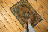 Antique Tabriz rug's scalloped central medallion with navy floral blossoms on terra cotta field.