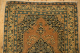 Antique Tabriz rug's terra cotta field, navy and ivory floral medallion, scalloped relief, and even pile wear.