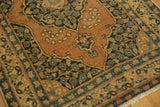 Corner of antique Persian Tabriz rug with floral blossoms, scalloped motifs, and patterned border.