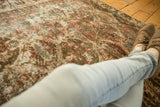 Distressed Baktiari rug texture with faded palmette motifs and visible foundation wear.