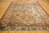 Vintage distressed Baktiari rug showing paneled motifs, varied wear, and faded wine red colors.