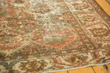 Distressed vintage Baktiari rug texture showing wear to knot heads, muted blush, green, ivory.