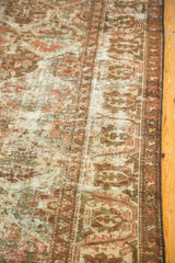Distressed vintage Baktiari rug detail showing worn pile, ivory foundation, and red-brown border.