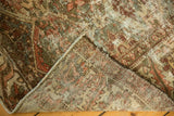 Folded corner of a vintage Baktiari rug reveals its distressed pile and hand-knotted foundation.