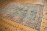 Distressed Malayer rug corner, blush red border with worn splayed floral palmettes.
