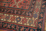 Textured border of the Kurdish carpet with madder root red and navy blue plant motifs.