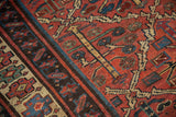 Kurdish rug's germinating plant motif in madder red, blues, saffron, and even pile wear.