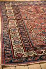 Vintage Kurdish rug's madder red field and cream main border with stylized motifs in blue and red.