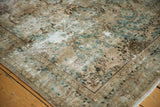 Distressed Kerman carpet corner revealing faded ocean green-blue European stylized vinery.