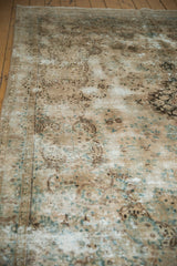 Weathered vintage Kerman carpet pile with ornate European stylized vinery in beige, blue, and brown.