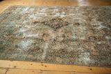 Distressed Kerman carpet corner with faded floral vinery, ocean green blue tones.