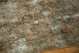 Distressed vintage Kerman carpet, showcasing faded floral motifs in beige and ocean green.