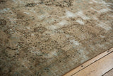 Worn pile on distressed Kerman carpet, showing intricate European floral vinery in beige, brown, green.