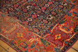 Antique Fragment Bijar rug: visible seam joining navy Herati field and red garden motifs.
