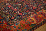Antique Bijar rug's corner showing navy Herati field and brick red early garden border.