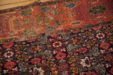 Seam joining antique Bijar rug fragments, revealing a worn red Herati field and a dense navy garden motif.
