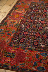 Distinct brick red garden style and navy Herati patterns meeting on the antique Bijar rug.