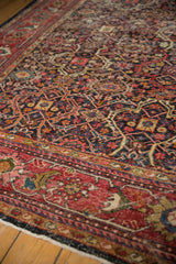 Vintage Mahal carpet section, cherry red border, navy field, with visible foundation wear.