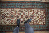 A view looking down at a vintage Hamadan rug runner, showing its distressed texture and scale underfoot.
