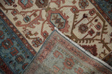 Folded corner of a vintage Hamadan rug revealing its dense hand-knotted foundation and secured edge.