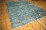 Traditional distressed Tabriz carpet with faded blue and red Herati patterns, showing even wear.