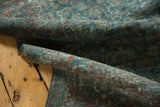 Distressed Tabriz carpet detail, showing softened pile with faded teal and wine red motifs.