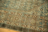 Vintage distressed Malayer carpet showing geometric border and faded teal, beige Herati pattern.