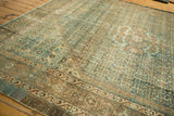 Vintage Distressed Malayer carpet corner, featuring faded teal and beige Herati patterns.