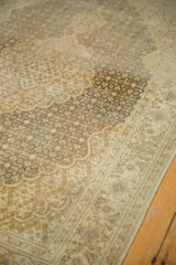 Distressed vintage Tabriz rug's Herati motif with varied pile texture in coffee and sand tones.