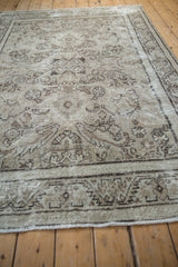 Distressed Mahal carpet detail showing antique ivory field, charcoal scrolling leaves, vines, and foundation wear.