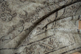 Folded vintage distressed Mahal carpet showing worn pile, subtle patterns, and foundation.