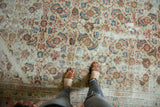 Distressed antique Sultanabad carpet with faded Herati motifs and visible worn texture.