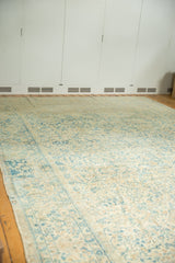 Distressed Kerman carpet, sky blue scrolling floral motifs, ivory field, and visible side border.