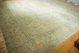 Distressed Kerman carpet with soft ivory, pale gold, and sky blue floral vines.