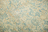 Distressed Kerman carpet showcasing intricate sky blue and pale gold floral vine motif.
