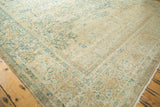 Distressed vintage Kerman rug's side border shows wear, faint foundation, and a repaired area.