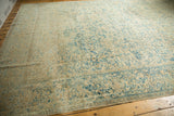 Distressed Kerman carpet featuring an allover faded ivory and pale blue scrolling floral pattern.