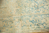 Vintage Kerman carpet's distressed ivory, sky blue floral motif, showing mostly even wear.