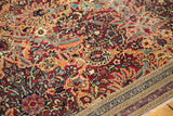 Intricate red, blue, and apricot floral palmettes on antique Persian Kerman carpet with ornate border.