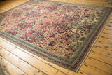 Corner detail of Antique Kerman, showing restored end, intricate navy border, cochineal floral pattern.