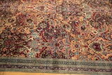 Rich cochineal red floral field and intricate blue-toned border on an antique Kerman.