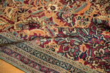 Intricate floral palmette pattern, deep cochineal red, blues, and detailed borders of antique Kerman.
