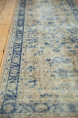 Distressed vintage Oushak runner pile, pale beige and cobalt blue floral motifs, showing knot heads.