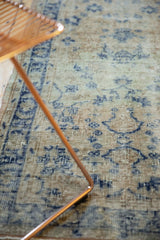 Distressed Oushak rug pile texture with faded floral patterns in beige and cobalt blue.